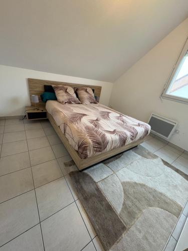 a bedroom with a bed and a rug on the floor at Appartement au calme proche du PAL in Digoin