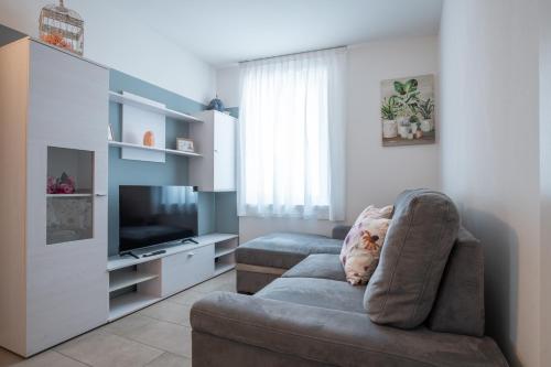 a living room with a couch and a television at ES Rooms and Apartments in Nago-Torbole