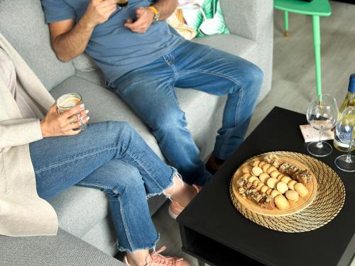two people sitting on the couch with glasses of wine at בוס-תן בגולן in Giv'at Yo'av