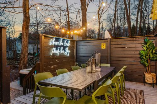 ein Holztisch und Stühle auf einer Terrasse in der Unterkunft Sleeps 15 Sauna Hot Tub Fire Pit & Putt Putt in Tobyhanna