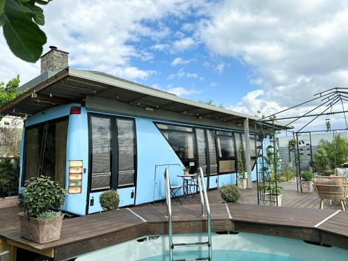 a tiny house with a deck next to a pool at בוס-תן בגולן in Giv'at Yo'av