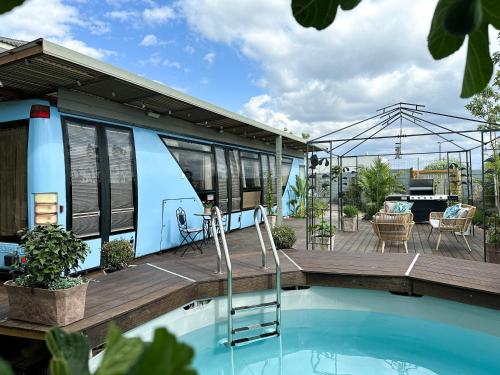 a tiny house with a swimming pool and a deck at בוס-תן בגולן in Giv'at Yo'av