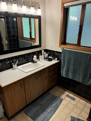a bathroom with a sink and a mirror at Bayview Bed and Breakfast in Mill Bay