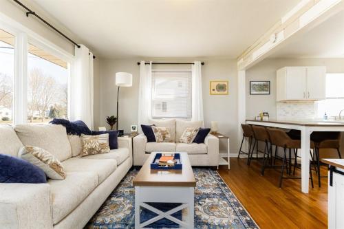 a living room with a white couch and a kitchen at Rockne's Rally - Updated 3BR 2BA Home 1 Mile from ND in South Bend