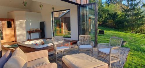 un salon avec une baignoire et des chaises dans l'établissement Maison Normande au bord de rivière avec spa et sauna, à Rugles