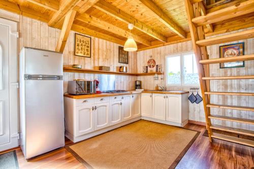 une cuisine avec des appareils blancs et un plafond en bois dans l'établissement Gîte 