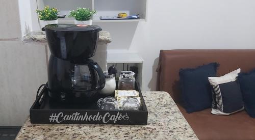 a black coffee maker sitting on a counter top at Brisa do Mar in Caraguatatuba