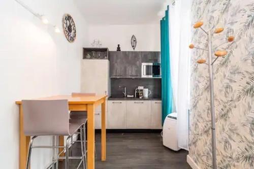 une petite cuisine avec une table et un réfrigérateur dans l'établissement AZUR STUDIO Hyper Centre Charmant Studio climatisé, Carré d'Or, à Cannes