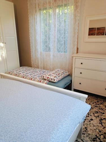 a bedroom with a bed and a dresser and a window at La casa di Piera in Sanremo