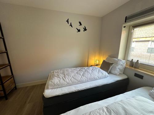 a bedroom with two beds and birds on the wall at HoeveLieshout - Lux 4 persoons platteland appartement in Weert