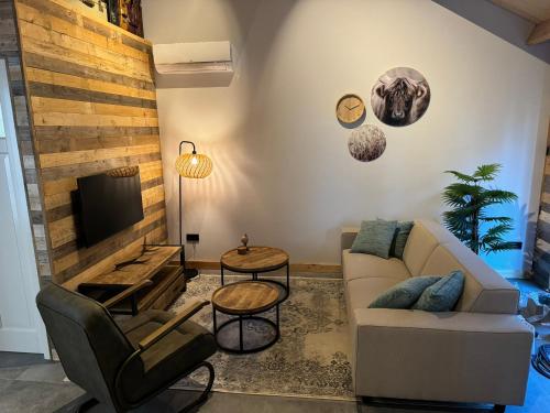 a living room with a couch and a tv at HoeveLieshout - Lux 4 persoons platteland appartement in Weert