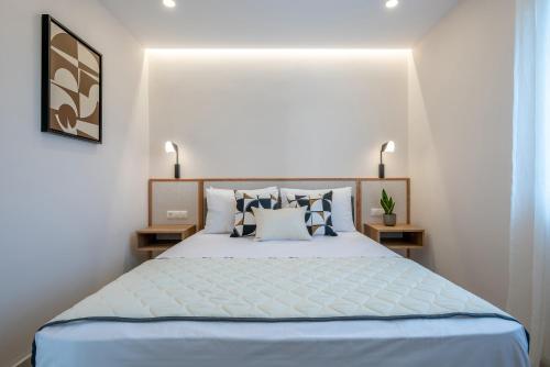 a bedroom with a large bed with blue sheets and pillows at Alysos Luxurious Apartments in Mirina