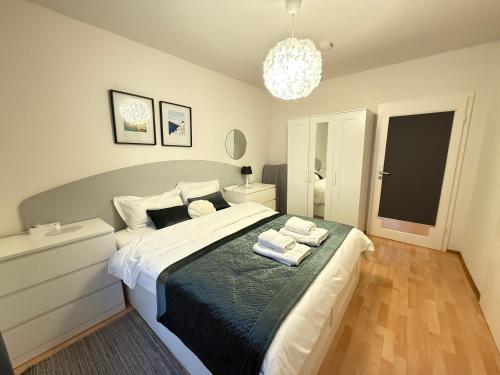 a bedroom with a large bed and a chandelier at Waldshut -Kaiser55 in Waldshut-Tiengen