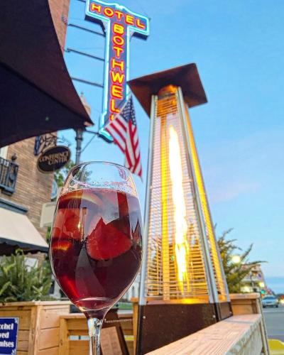 a glass of wine sitting in front of a sign at Hotel Bothwell Sedalia Central District, an Ascend Collection Hotel in Sedalia