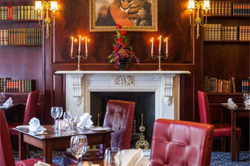 a restaurant with tables and chairs and a fireplace at Exeter Rougemont Hotel by Sunday in Exeter
