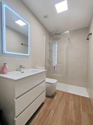 a bathroom with a sink and a toilet and a mirror at Estudio El Santo 1 in Salamanca