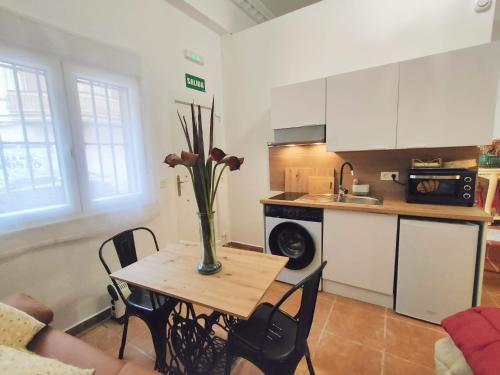 Una cocina con una mesa con un jarrón de flores encima. en Estudio El Santo 1, en Salamanca
