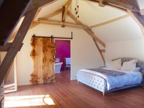 une chambre avec un lit dans un grenier dans l'établissement Stunning French farmhouse, à Puylagarde