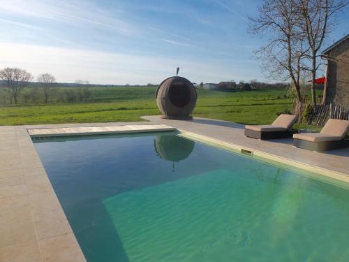- une piscine avec 2 chaises à côté d'un champ dans l'établissement Stunning French farmhouse, à Puylagarde
