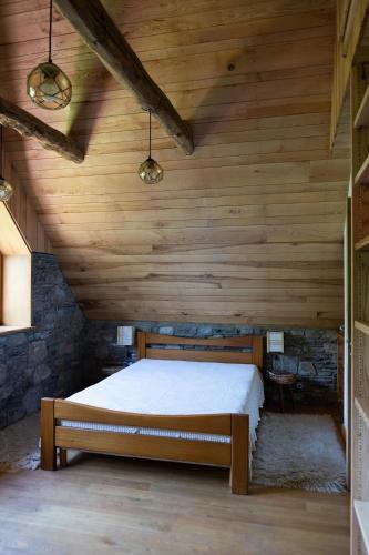 - une chambre avec un lit au plafond en bois dans l'établissement Authentique grange rénovée 1100 m altitude, à Loudenvielle