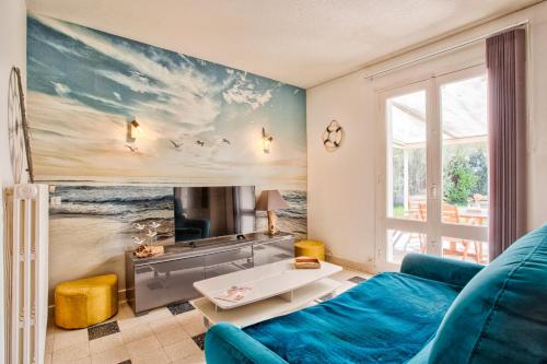 un salon avec un canapé bleu et une fenêtre dans l'établissement Gîte L'Escapade - face au golf et à 3 min de la plage de Barneville, à Barneville-Plage