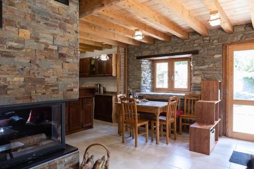 une cuisine avec une cheminée, une table et des chaises dans l'établissement Authentique grange rénovée 1100 m altitude, à Loudenvielle