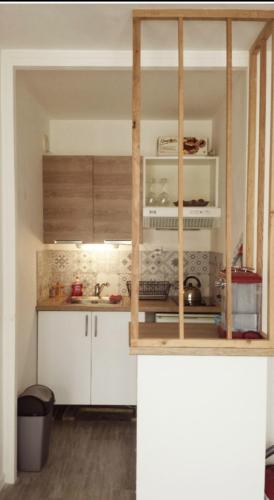 une cuisine avec des armoires blanches et un évier dans l'établissement Studio proche de la mer, à Saint-Quay-Portrieux