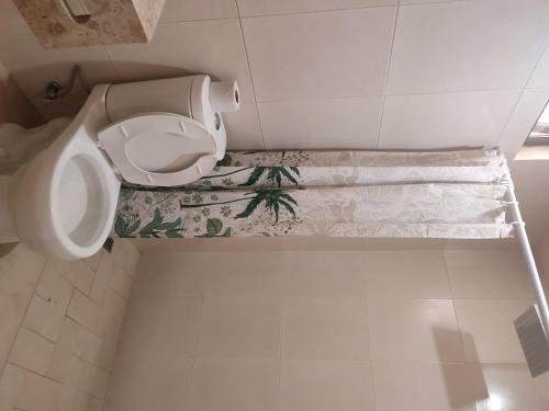 a white bathroom with a toilet and a floor at Hotel TORTUGA REAL in Santa Cruz Huatulco