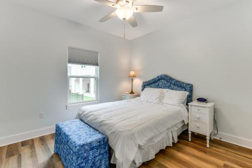 Schlafzimmer mit einem Bett mit blauem Kopfteil und einem Fenster in der Unterkunft Walk to Beach and Harbor Dtwn Pass Christian Home in Pass Christian