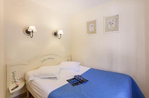 - une petite chambre avec un lit et une couverture bleue dans l'établissement les Restanques Du Golf de Saint Tropez, 83310 Grimaud, France Appartement, à Grimaud