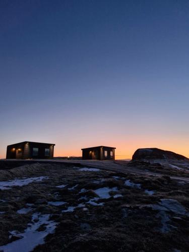 two buildings on top of a hill at sunset at Bygghamar in Stykkishólmur