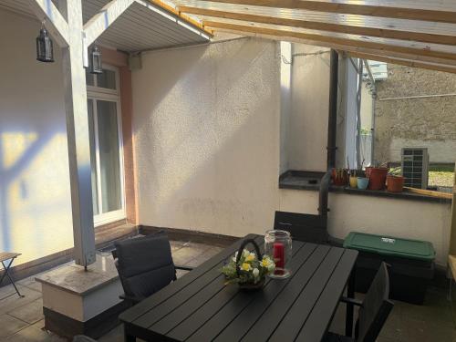 a wooden table with a vase of flowers on a patio at Waldshut -Kaiser55 in Waldshut-Tiengen