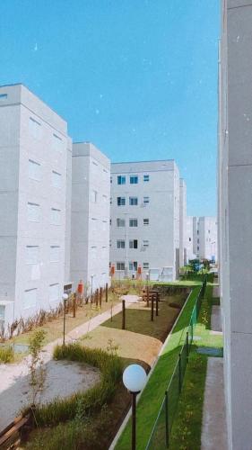 a large white building with a park in front of it at Aconchego Da Diane - Enseada in Guarujá