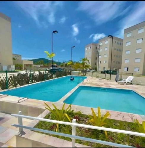 a swimming pool at a resort with buildings at Aconchego Da Diane - Enseada in Guarujá