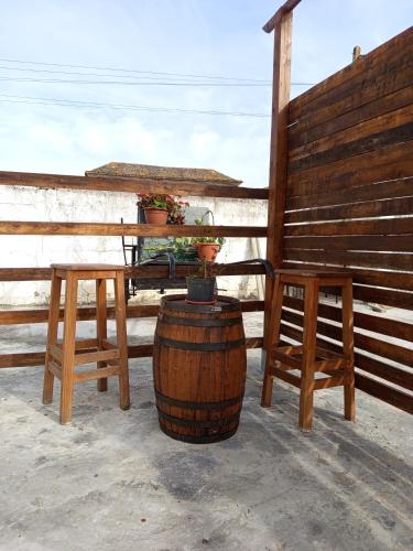 a table and two stools and a barrel with a table and chairs at El Girasol yellowstone in Chiclana de la Frontera