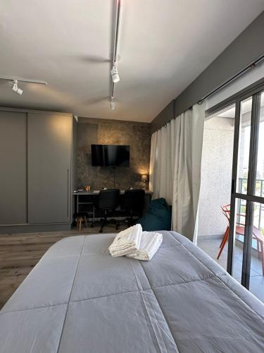 a bedroom with a large bed and a television at Liberdade Loft & Comfort in São Paulo