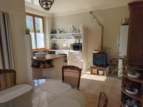 une cuisine avec une table et des chaises dans une pièce dans l'établissement Les Roises, à Montigny-devant-Sassey