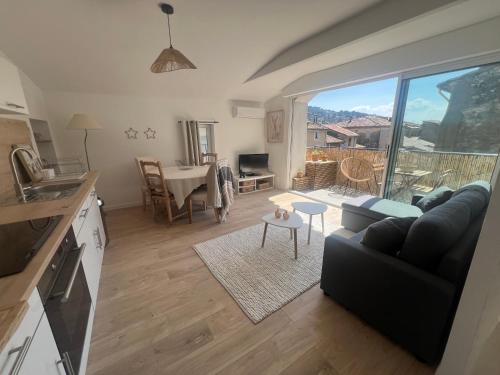 une cuisine et un salon avec un canapé et une table dans l'établissement Appartement rénové avec terrasse, à Anduze