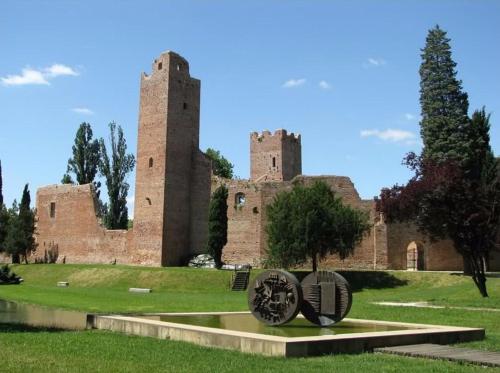 a castle with two towers and a statue in front of it at Novalesi Red House in Noale