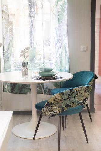 une table et des chaises blanches avec une plaque de cuisson dans l'établissement Cozy apartment - Downtown Place d'Erlon, à Reims