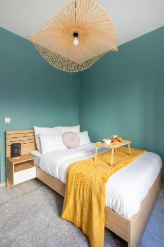 une chambre avec un lit et un mur bleu dans l'établissement Cozy apartment - Downtown Place d'Erlon, à Reims