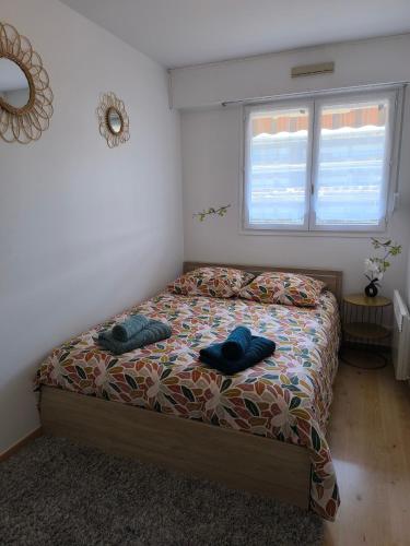 une chambre avec un lit avec deux serviettes dessus dans l'établissement La Lanterne, à Villers-sur-Mer