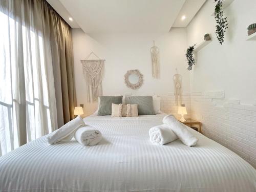 a white bedroom with a large bed with towels on it at Boho 2BR Cozy App Jacuzzi & Pool in Rabat