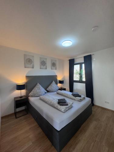 a bedroom with a bed and two lamps and a window at Ferienwohnung Nalbach Wohnung 1 in Nalbach