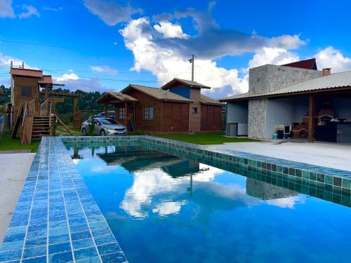 a swimming pool in front of a house at Chalé Cantinho da Paz in Santa Teresa