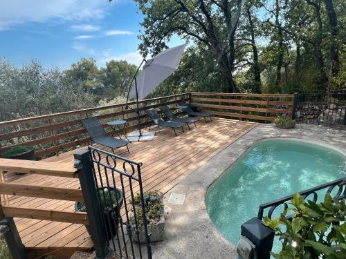 - une terrasse avec des chaises et un parasol à côté de la piscine dans l'établissement Villa Robinson Belvedere, à Montauroux