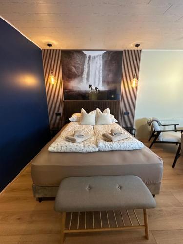a bedroom with a bed with a painting on the wall at Hoofprints&Highlands in Fludir
