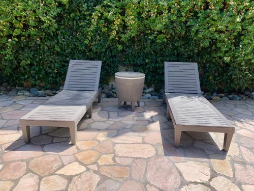two benches and a trash can on a stone patio at Homestay in Hayward