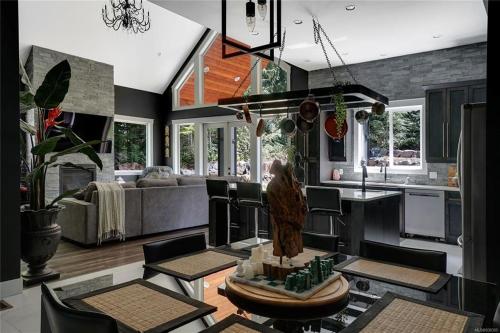 a kitchen and living room with a table and chairs at Shawnigan Lake Retreat with Theatre in Shawnigan Lake