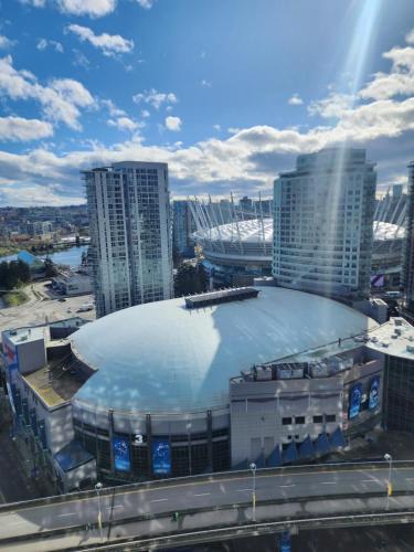 a large building with a rink in front of a city at Modern High-Rise 1 Bedroom Condo with water view near stadiums in Vancouver